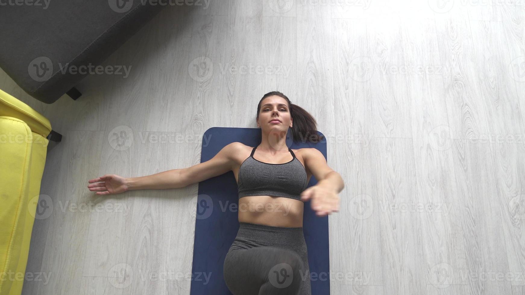 Beautiful young woman doing exercises on the floor at home photo