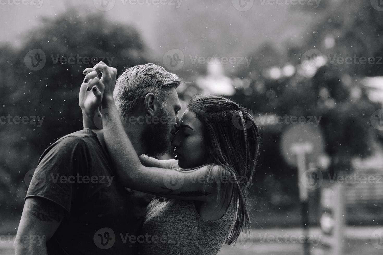 hermosa pareja besándose bajo la lluvia foto