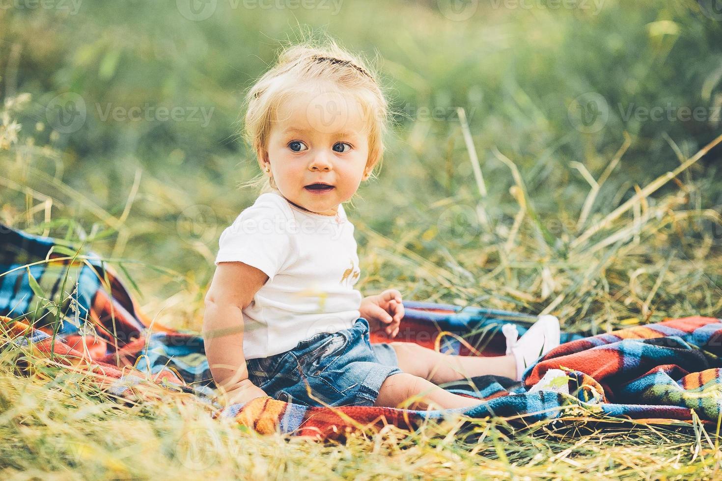 little girl sitting on the lawn photo