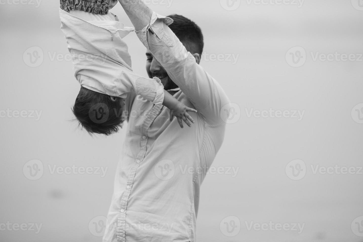 Dad holding infant son by his feet photo