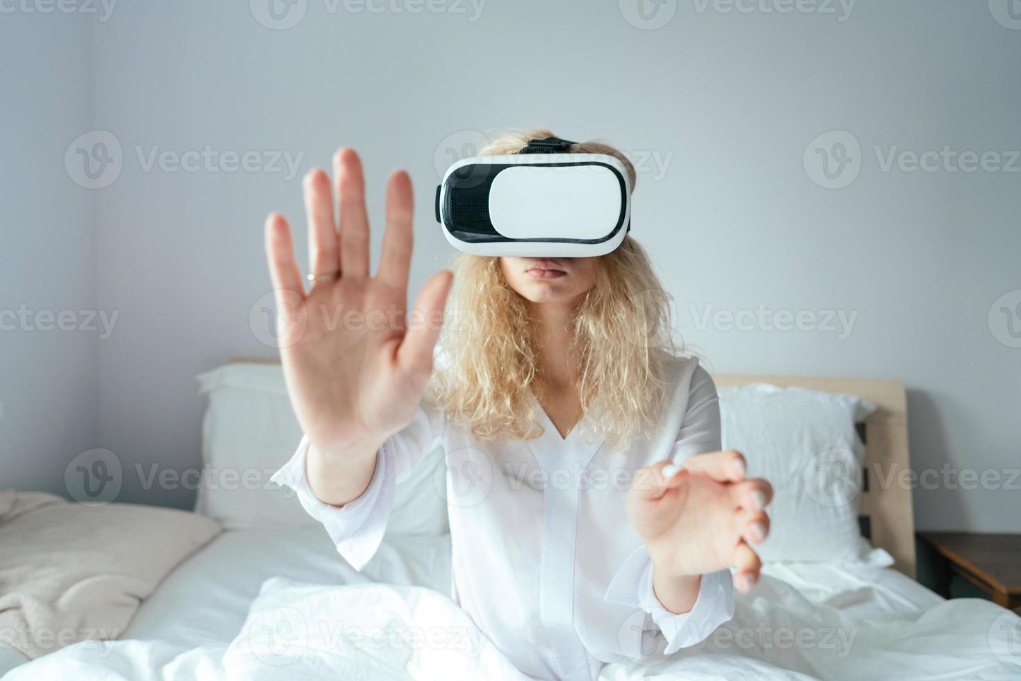 niña sentada en una cama con auriculares vr foto