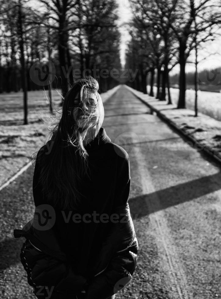 retrato de una chica morena divirtiéndose en un parque bajo los rayos del sol brillante. foto