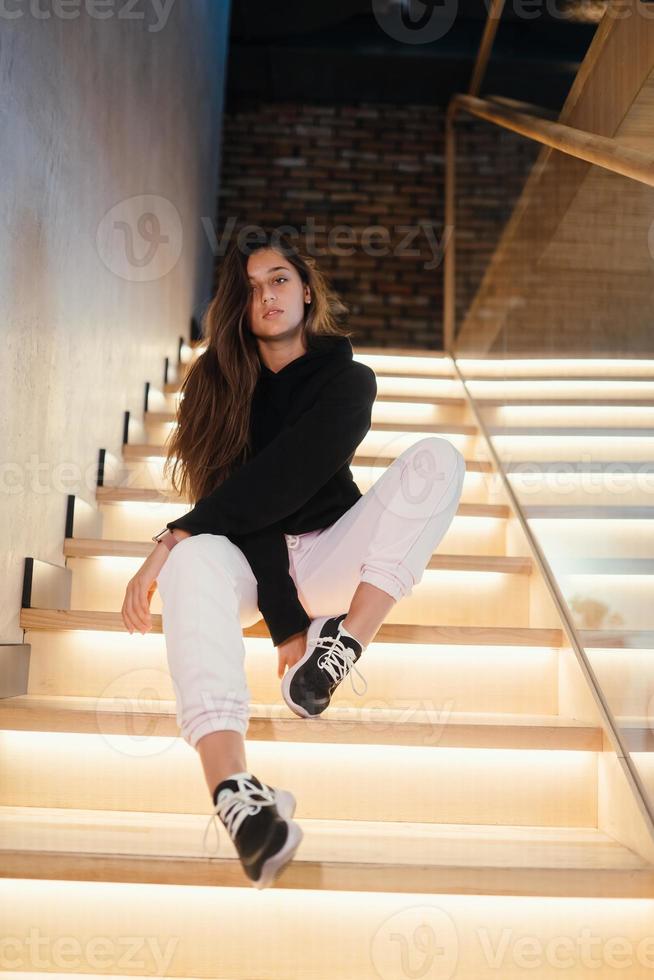 Young beautiful brunette fashion model posing on stairs. photo