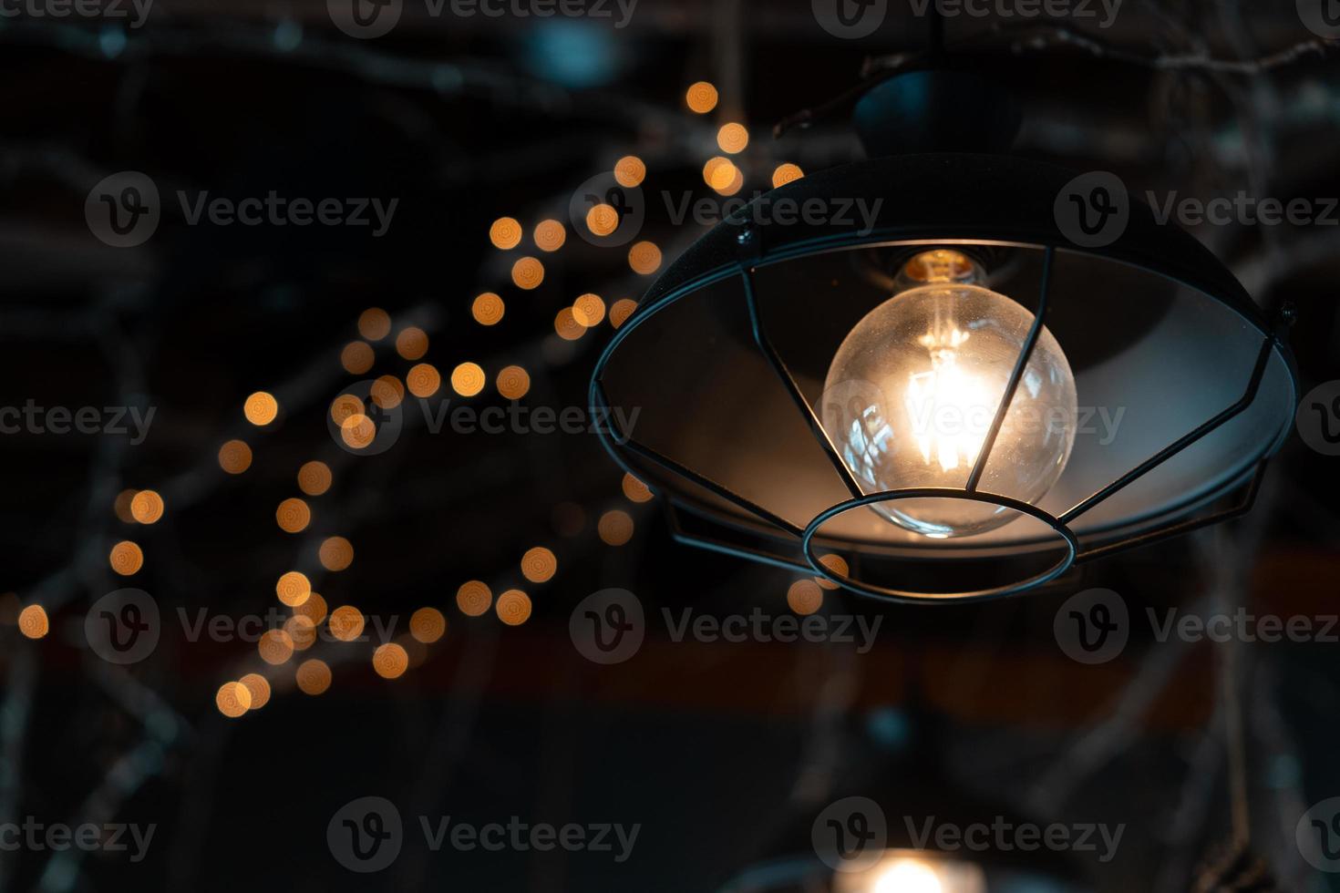 Lamp hanging outside on a dark background. photo