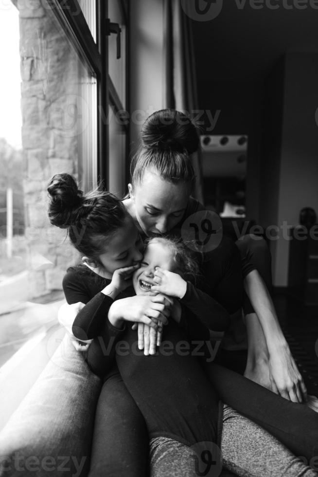 mamá y dos hijas juntas en la ventana foto