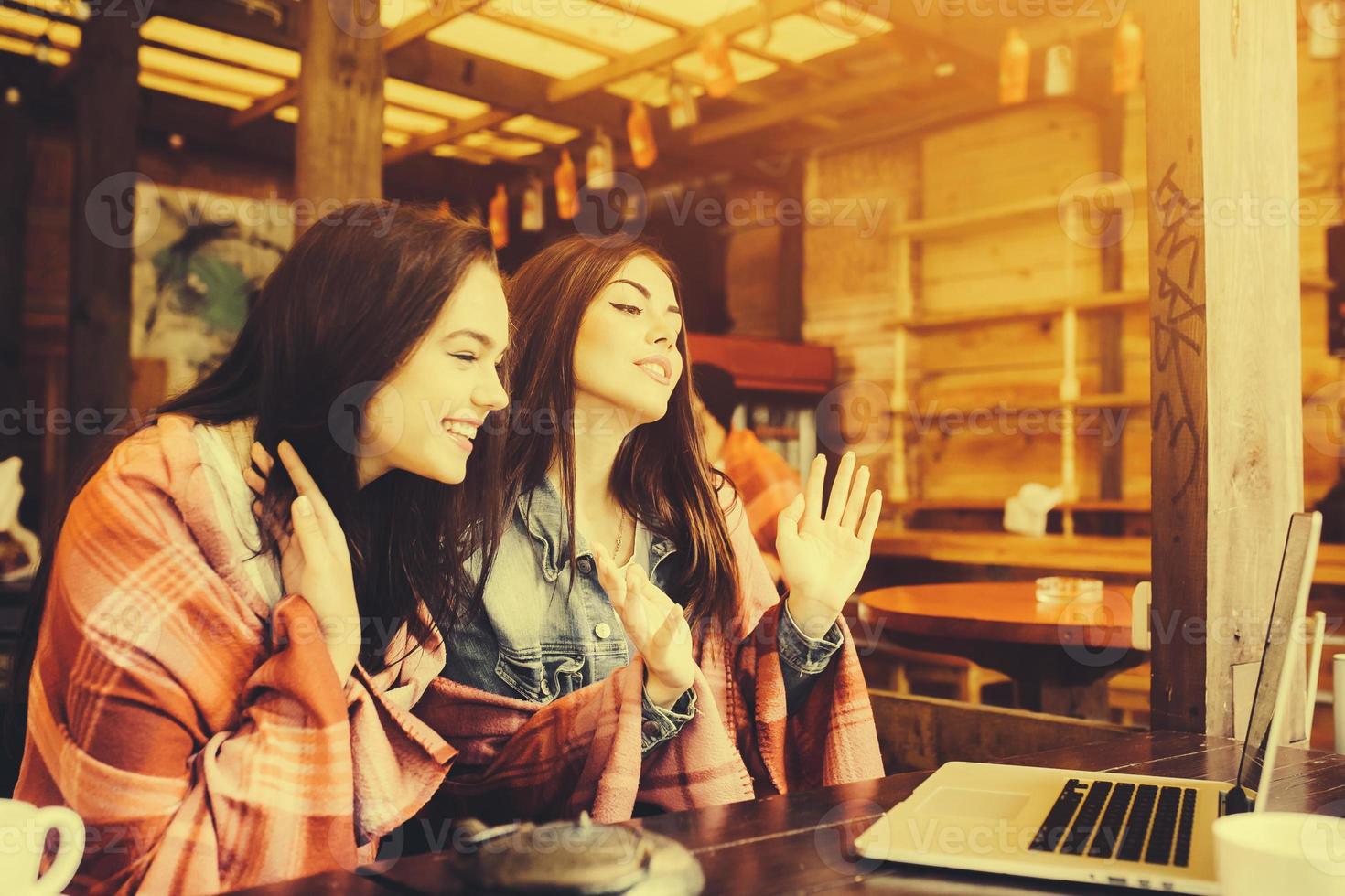 two girls watching something in laptop photo