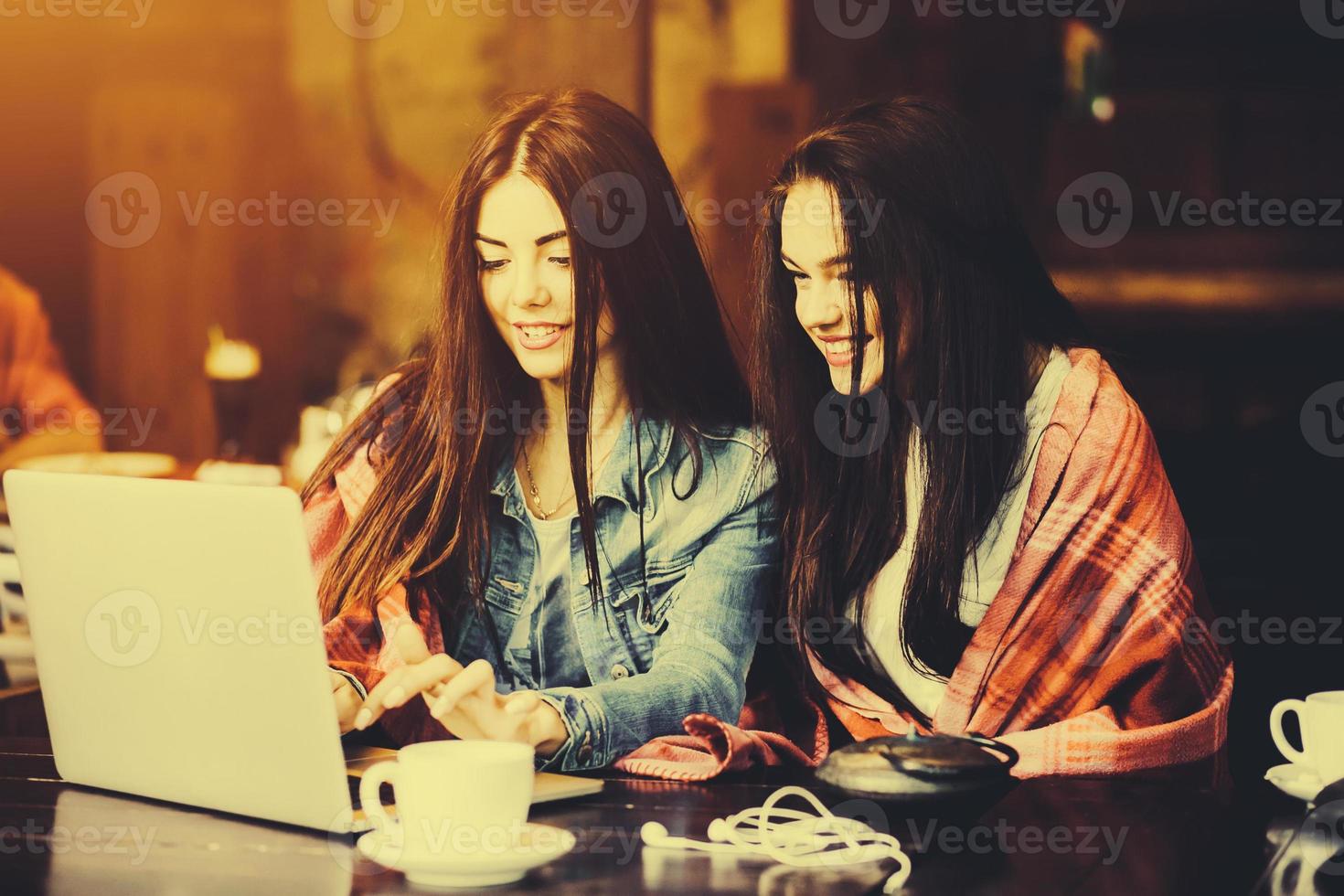 two girls watching something in laptop photo