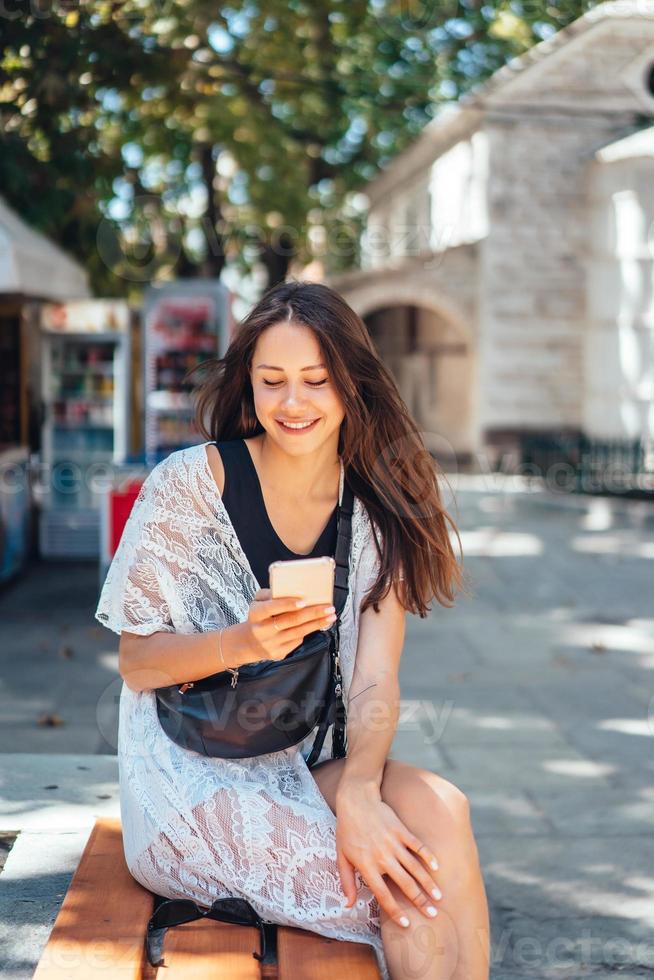 A girl is holding a phone and posing on the camera. The Internet. Message. photo