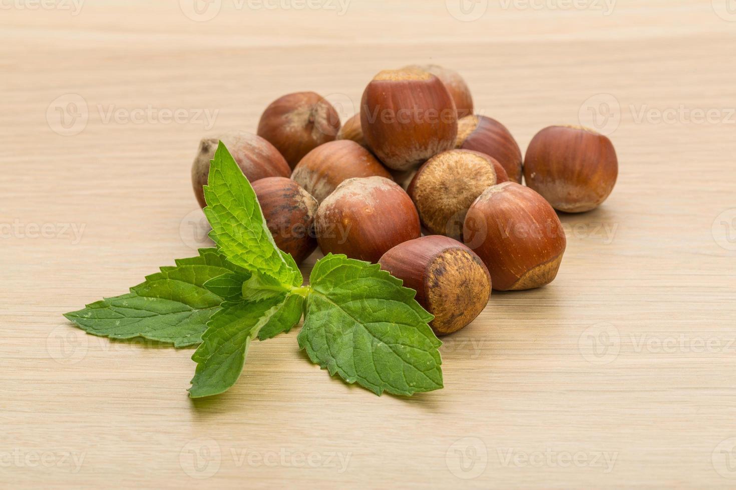 Hazelnut heap on wooden background photo