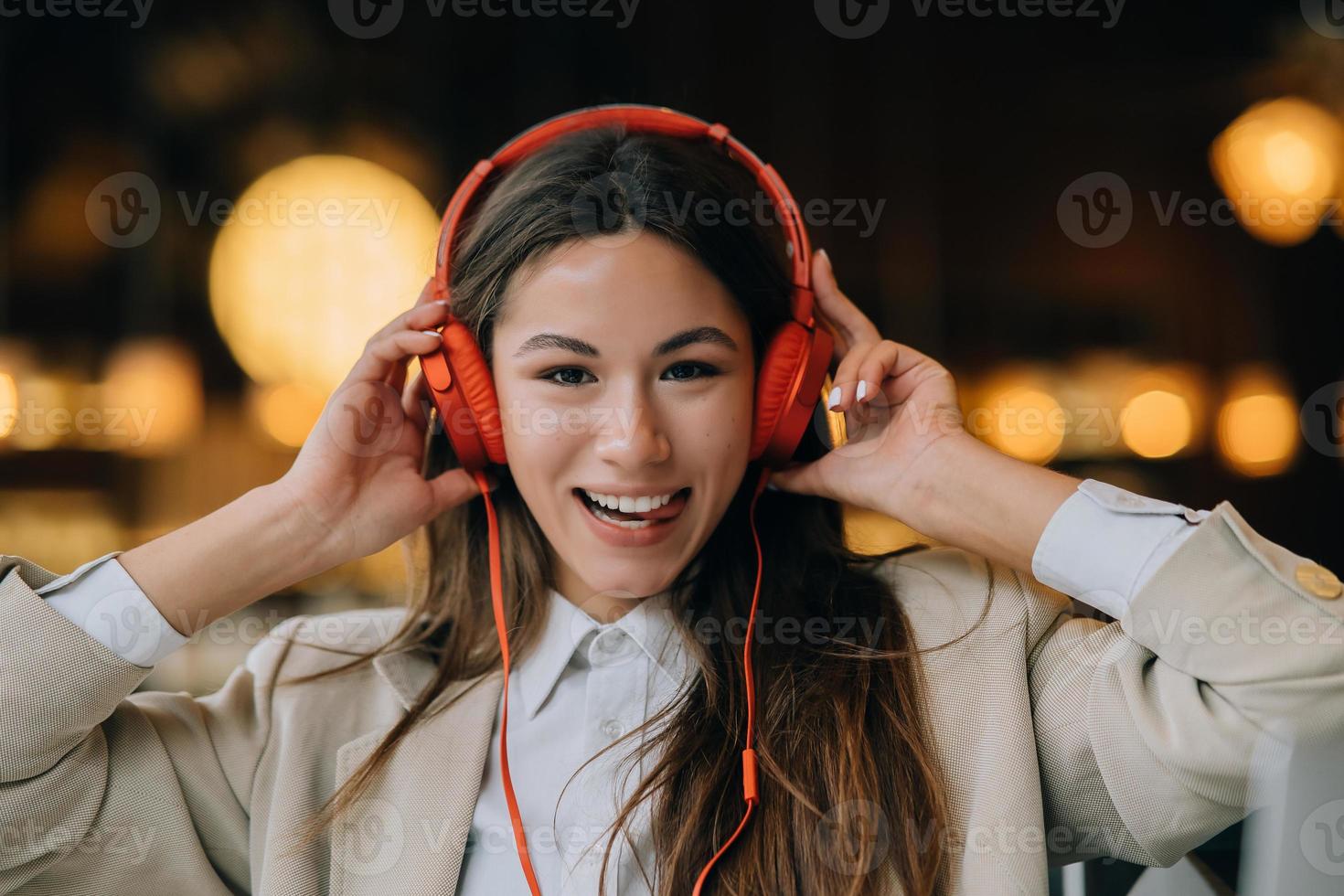 mujer joven con auriculares escucha música mientras se sienta en los cafés foto