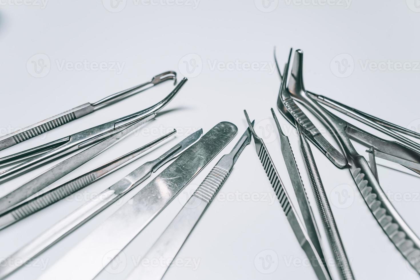 Several surgical instruments lie on a white table photo