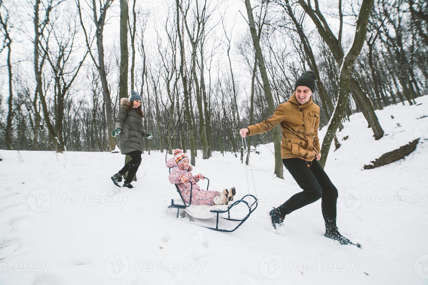 Dad and Mom with a little daughter in the park photo