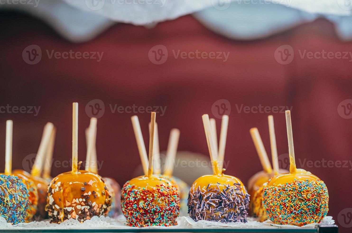 Apples in caramel and sprinkles. Street food. photo