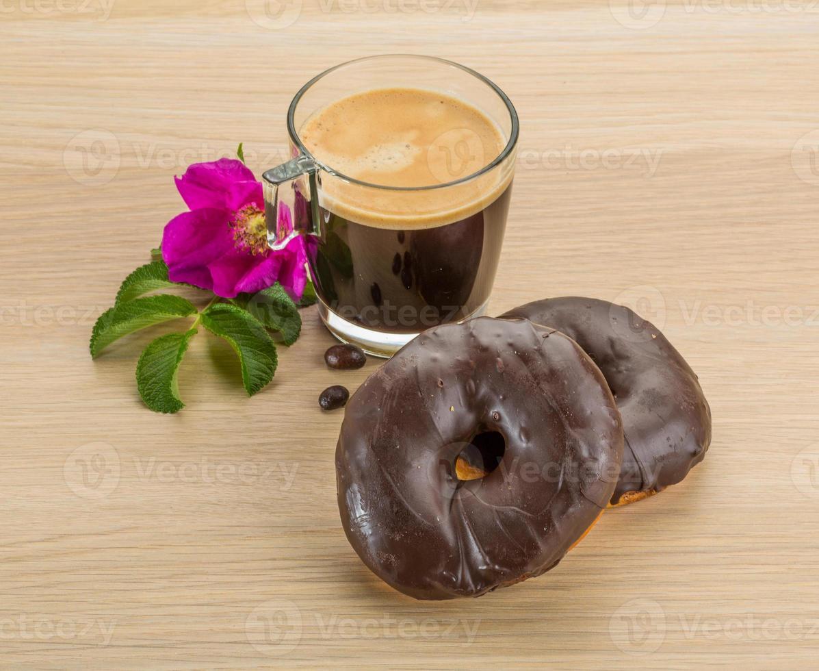 Coffee with Chocolate donuts on wooden background photo