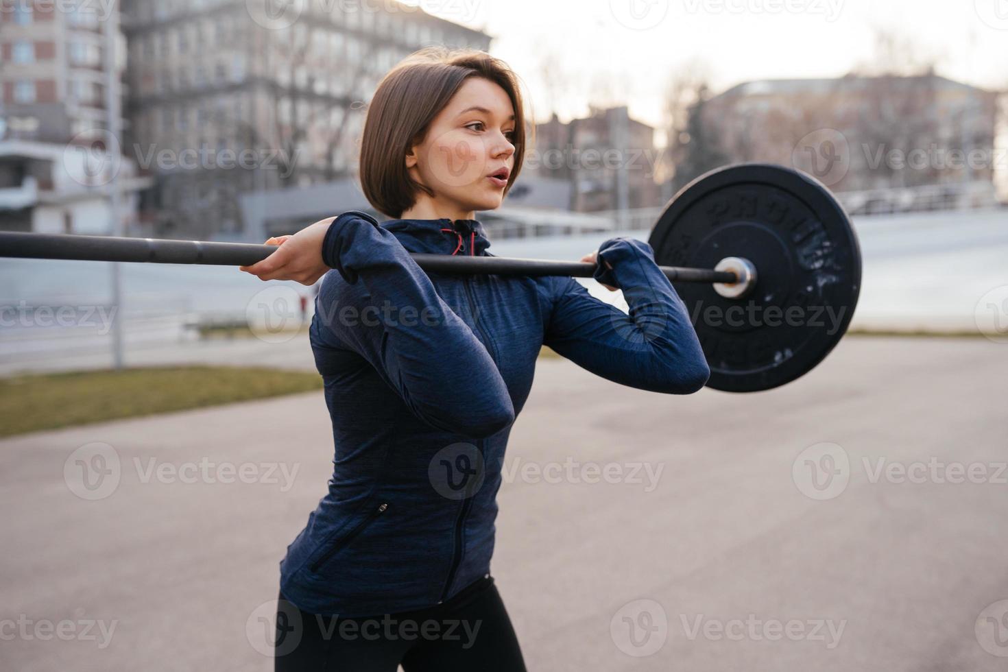 mujer fuerte haciendo ejercicio con barra. deportes, concepto de fitness. foto