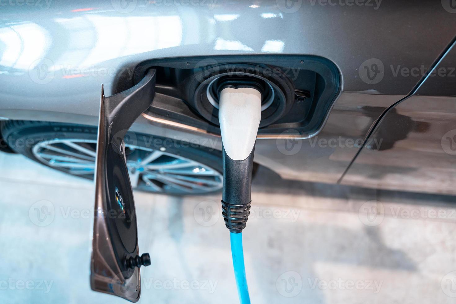 Power supply plugged into an electric car being charged. photo