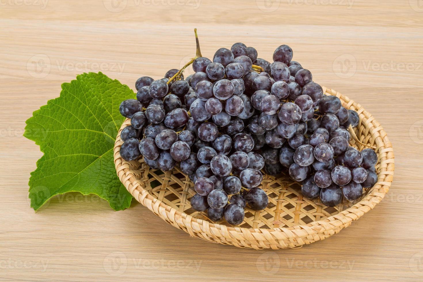Grape in a basket on wooden background photo