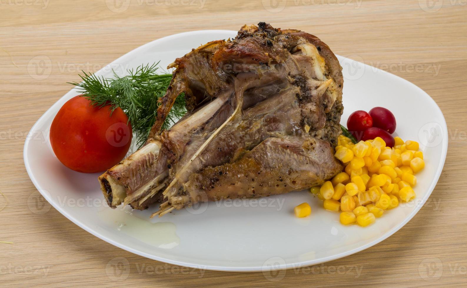 Roasted turkey leg on the plate and wooden background photo