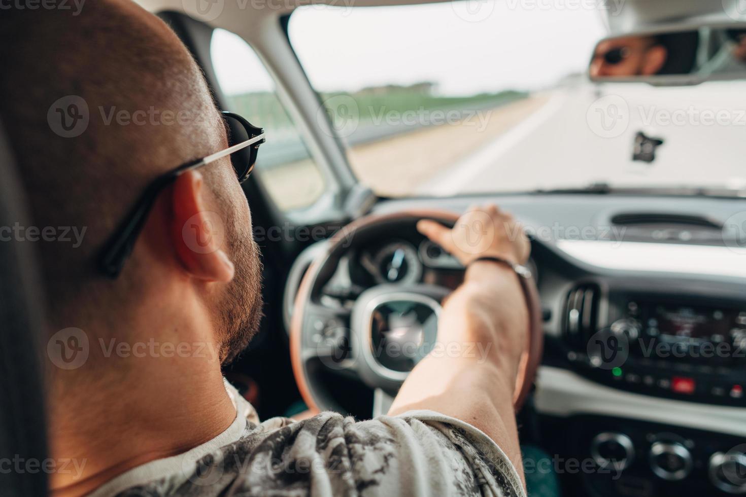 The man in the car traveling on the road photo