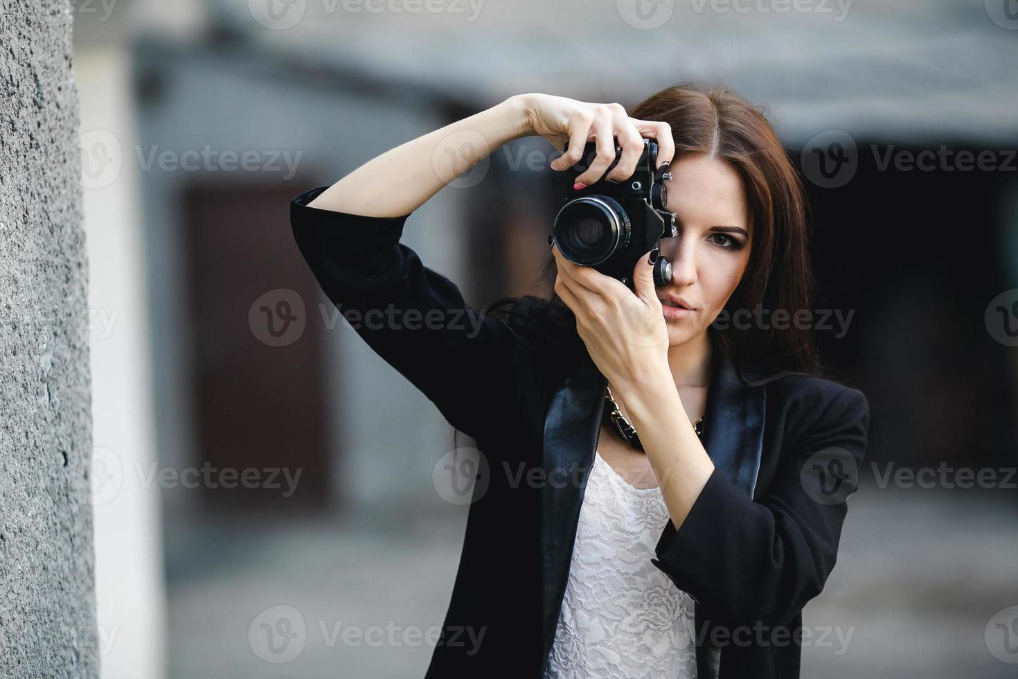 Beautiful female photographer posing with camera photo