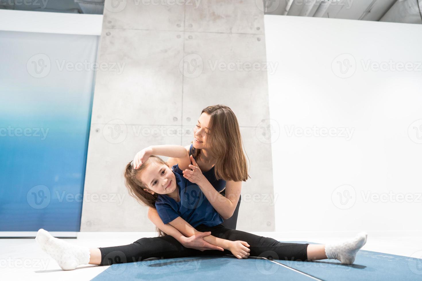 Mom and daughter do stretching before exercise photo