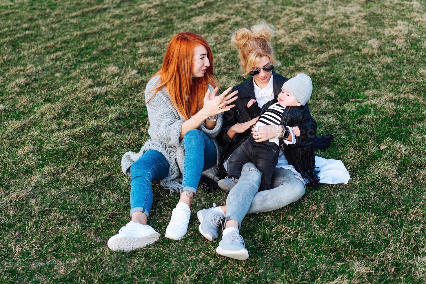 Mom and aunt play with a boy in the Park photo