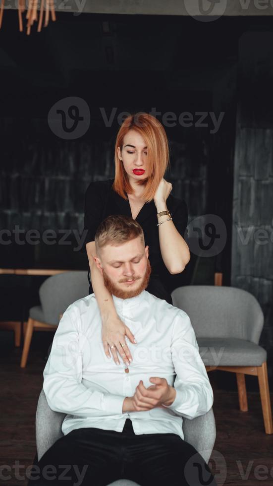 A young woman and her boyfriend are posing for the camera indoors. photo