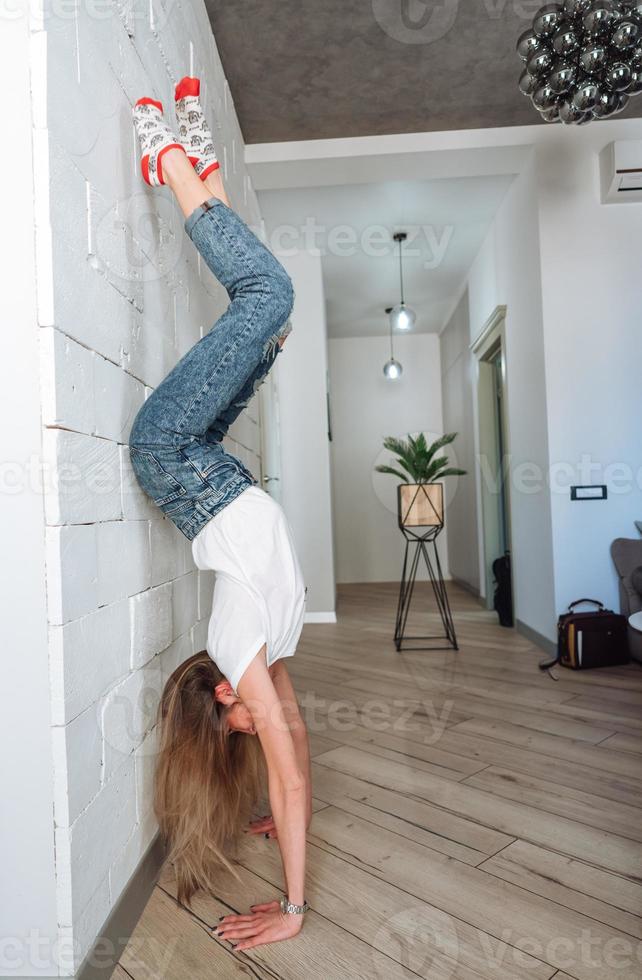 A woman is standing on his hands upside down photo