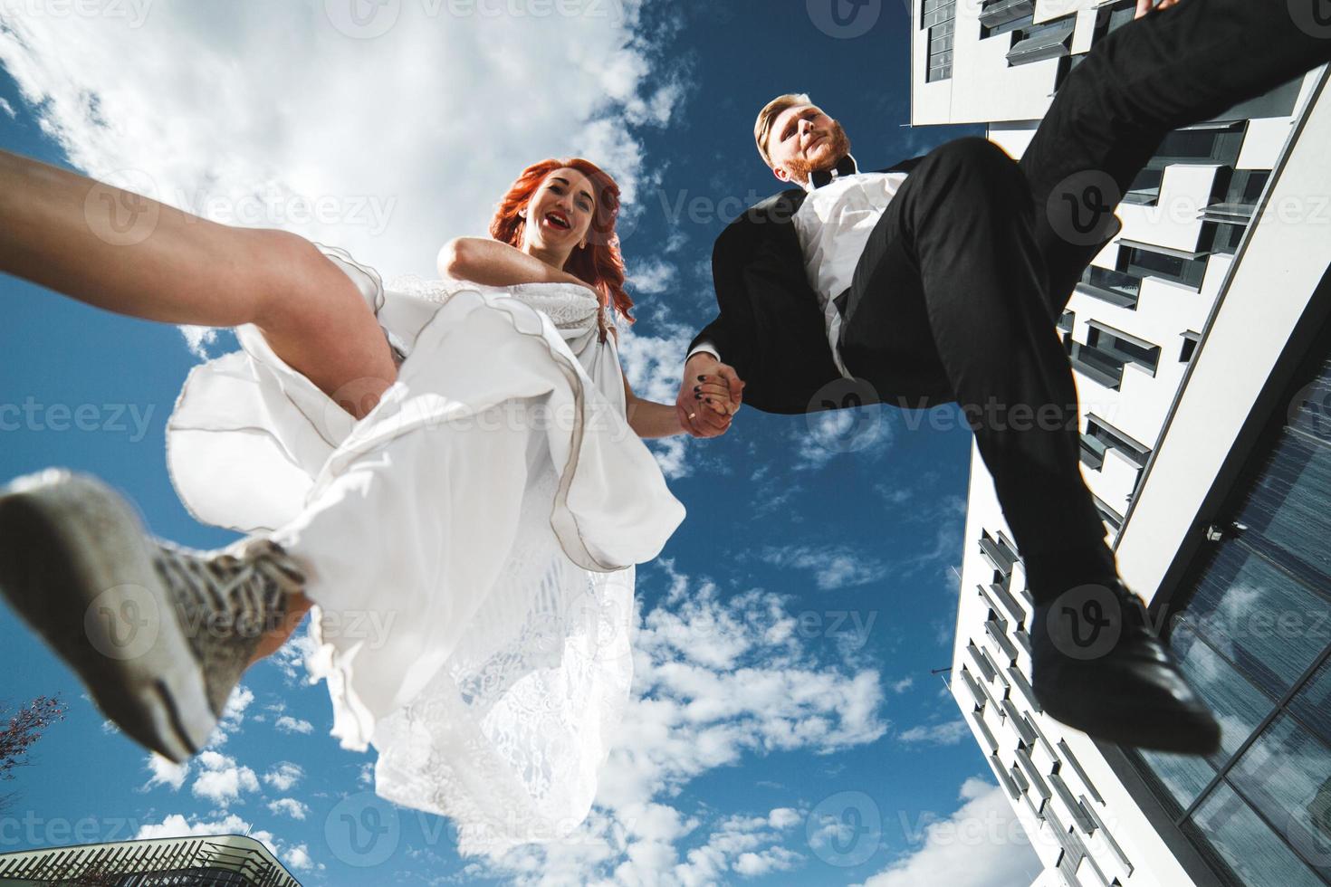 pareja de novios saltando en un edificio futurista foto