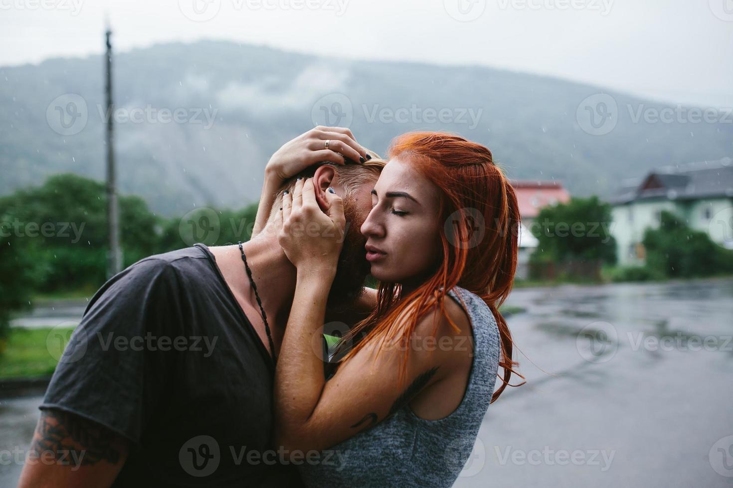 beautiful couple hugging in the rain photo