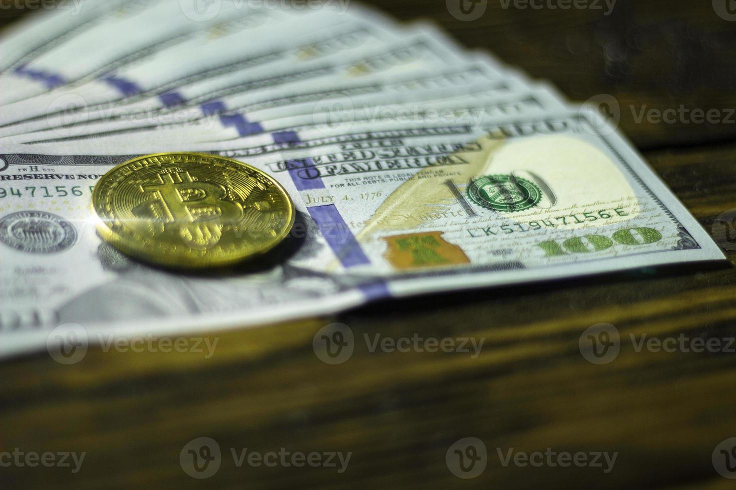 Bitcoin cryptocurrency coin and dollars on a wooden surface photo