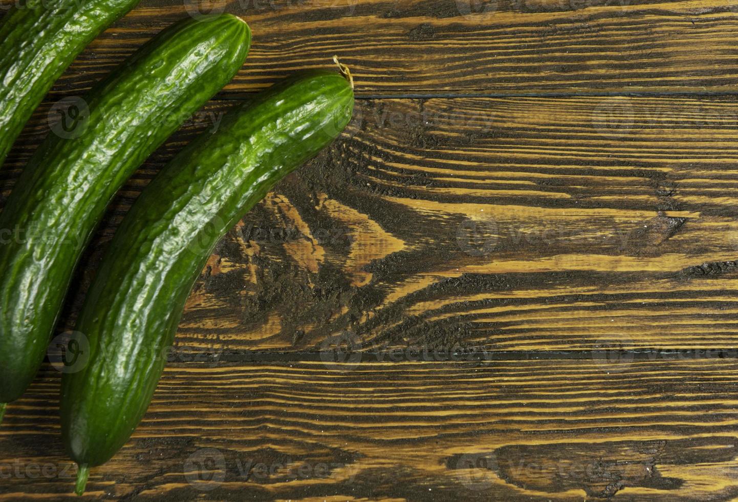 Fresh green cucumbers isolated on wooden background photo