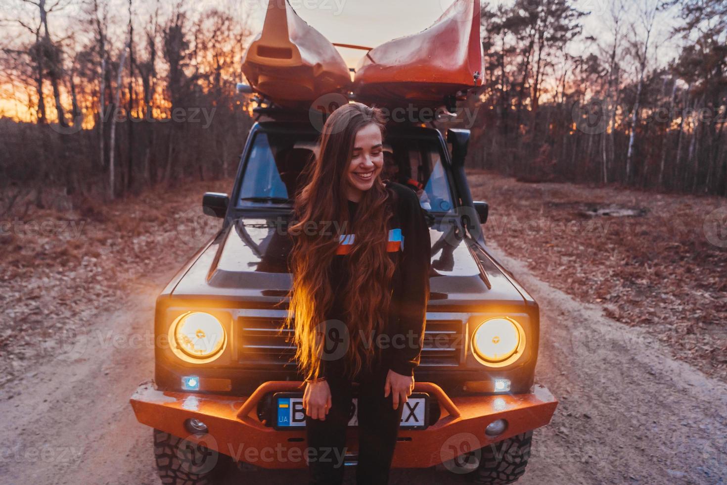 Woman stands front off 4x4 terrain vehicle. photo