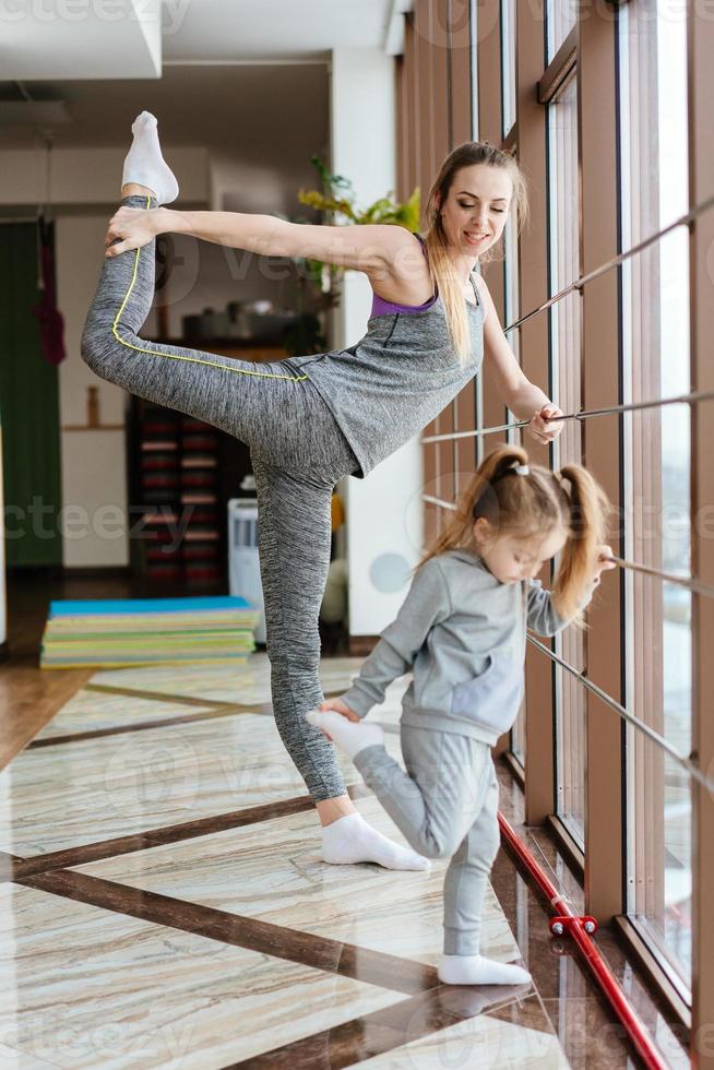 Mom and daughter together perform different exercises photo