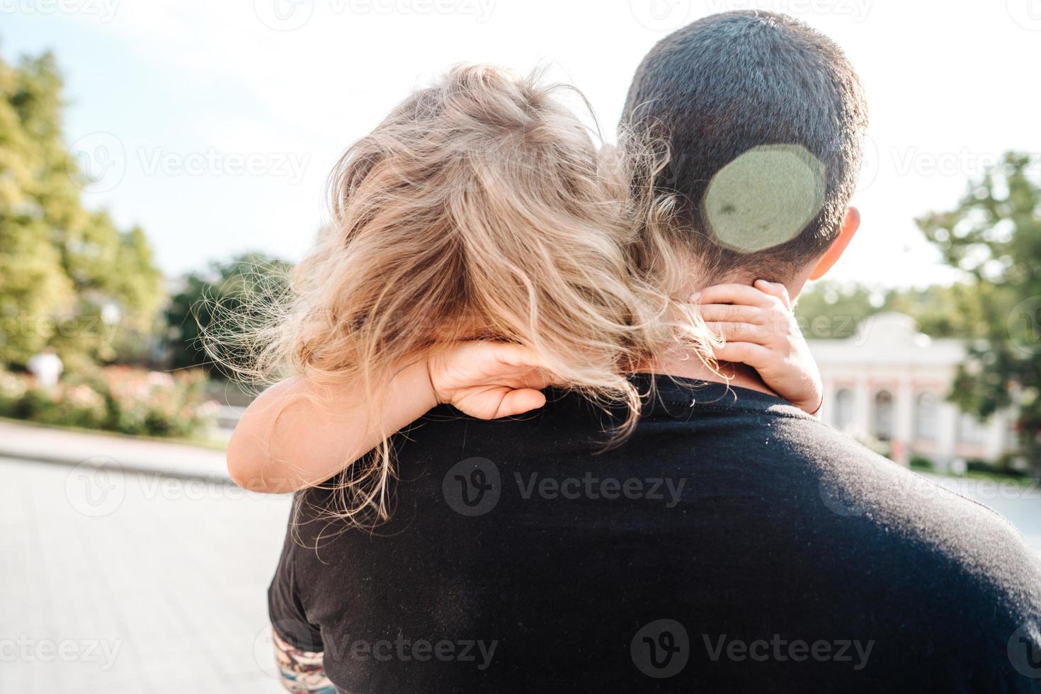 Little girl resting on her father's shoulder photo