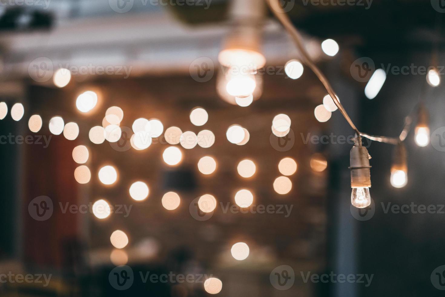 Lamp on garland with lights on background photo