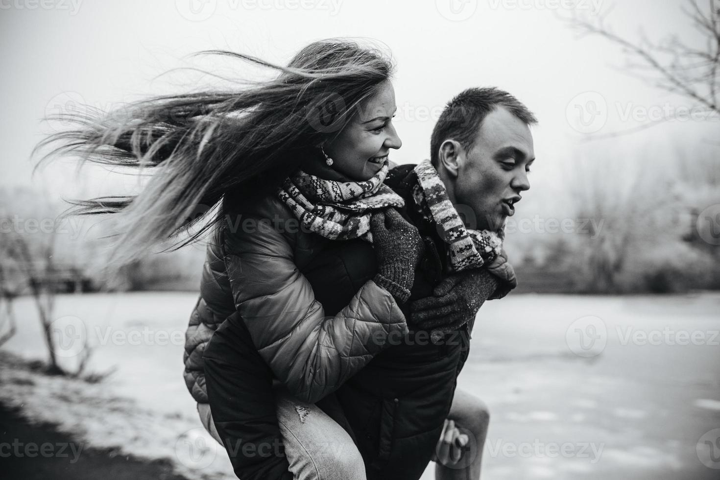 man carries his girlfriend on back photo