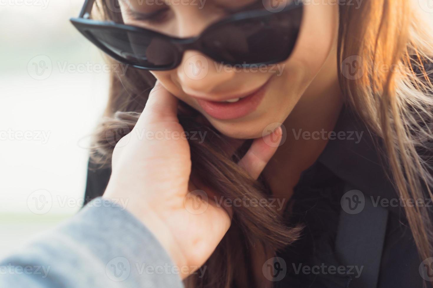 The guy gently holds the girl's hair photo
