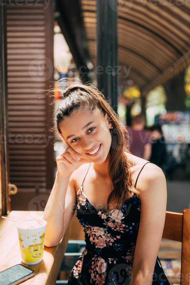 atractiva joven caucásica sentada en un café de la calle foto