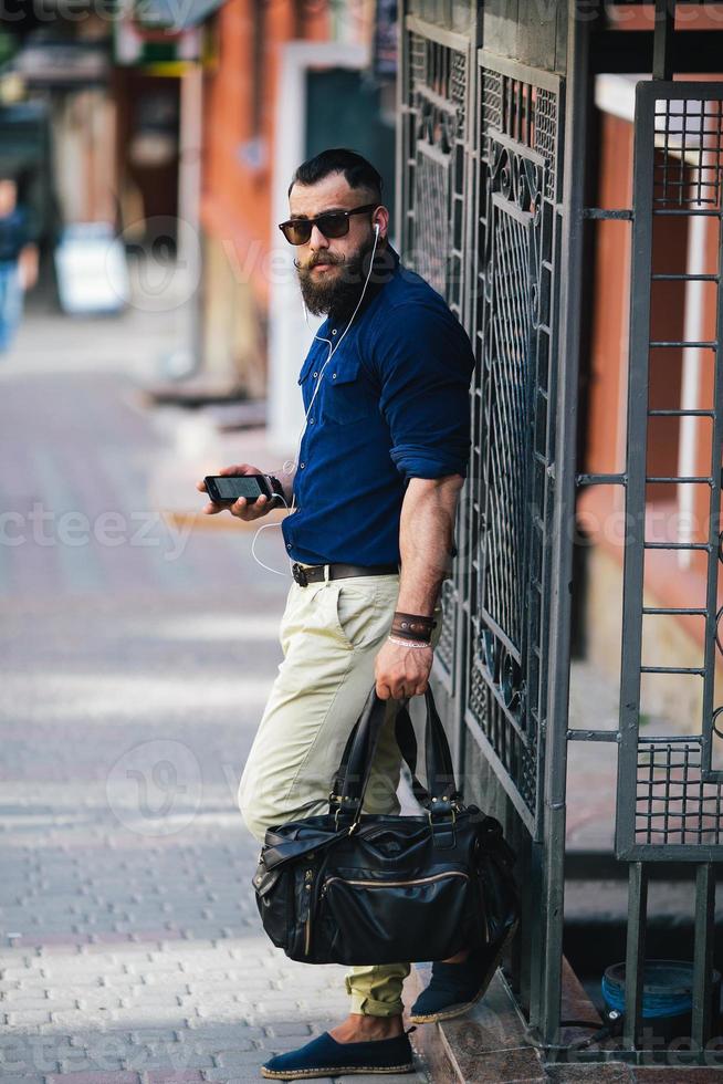 bearded man standing and listening to music photo