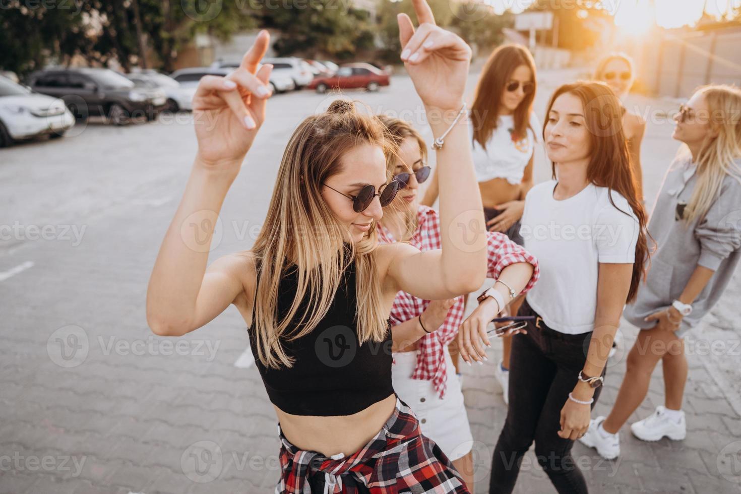Six young women dance in a car park photo