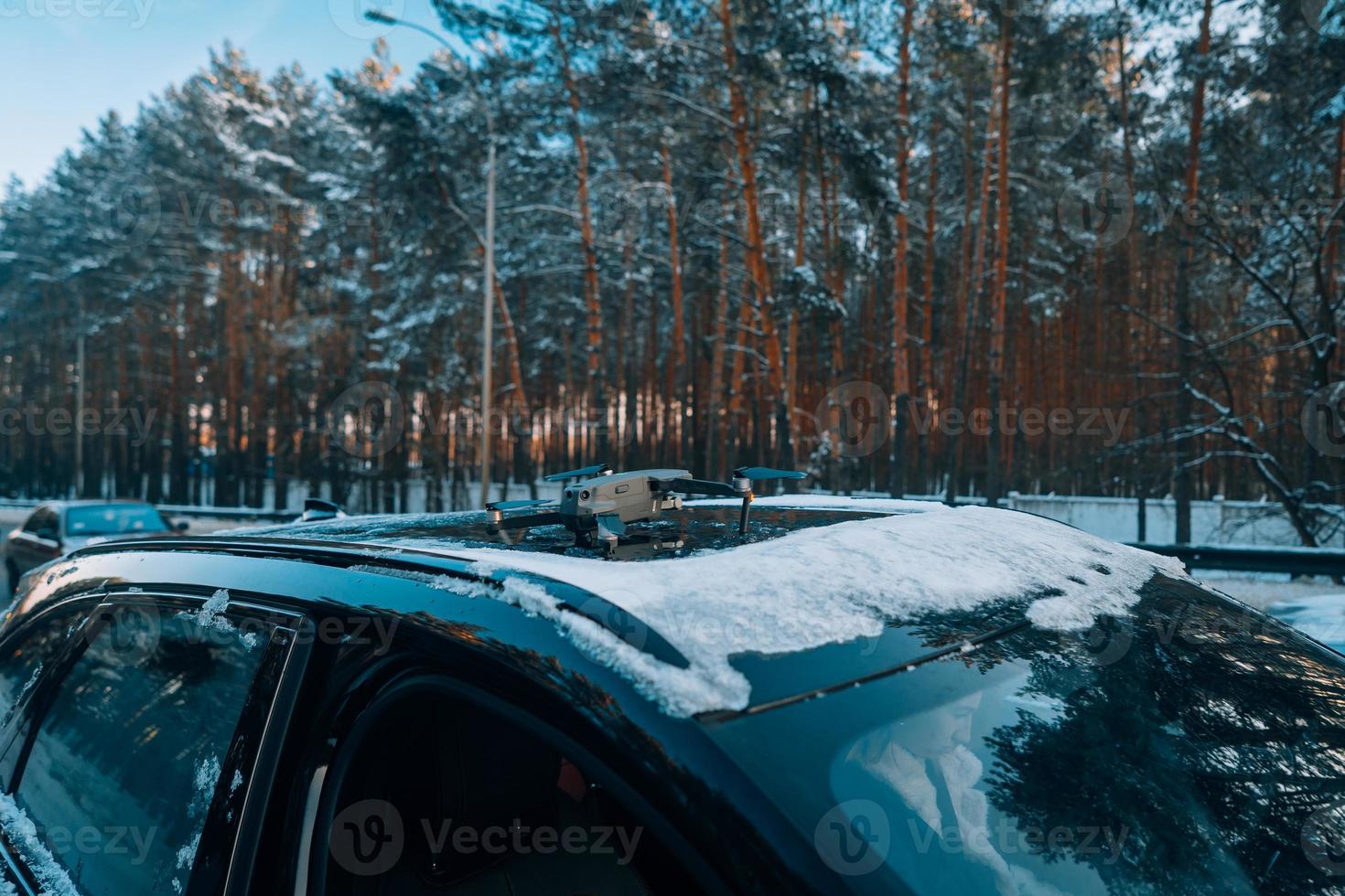 Drone standing on the roof of a snow-covered car photo