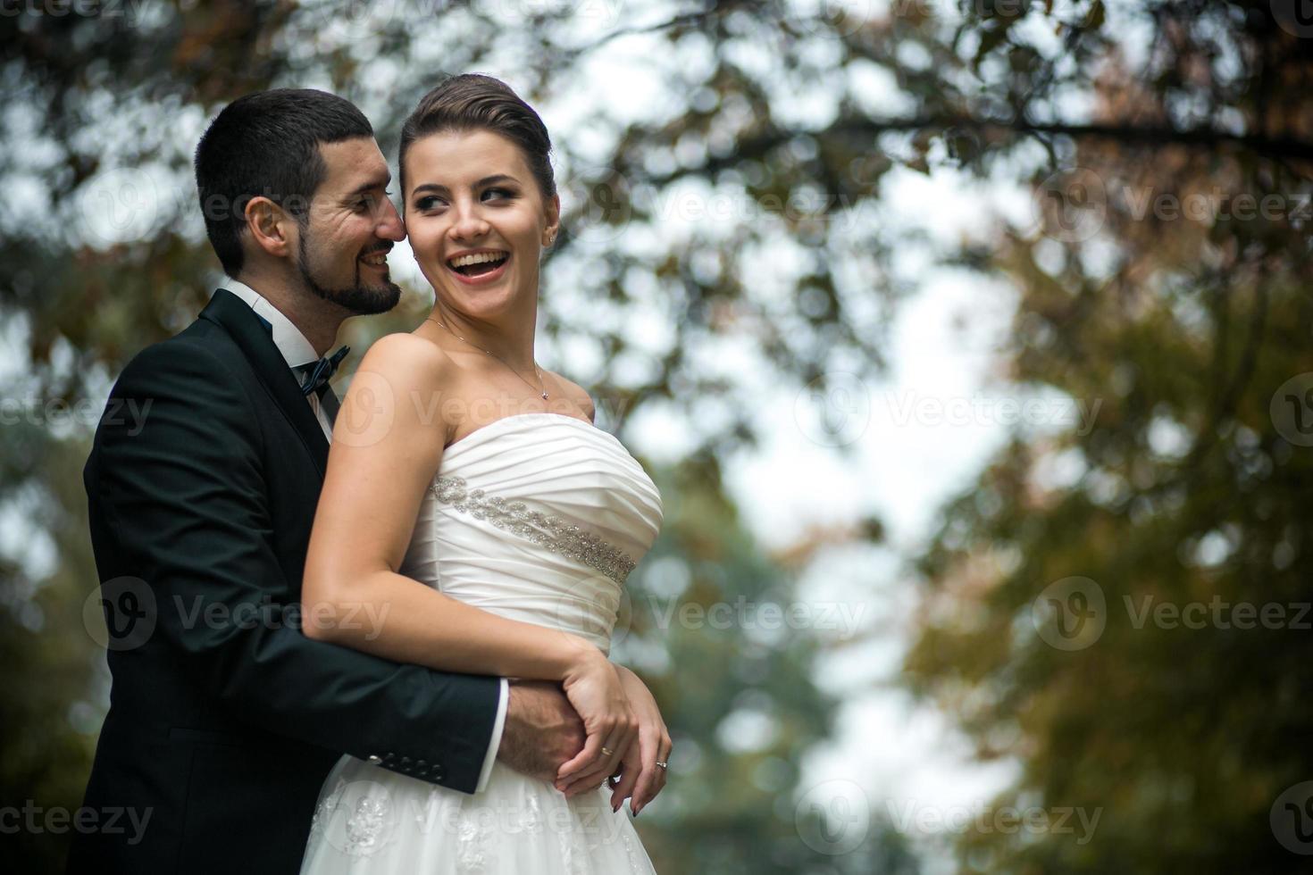 novio abrazando a la novia desde atrás foto