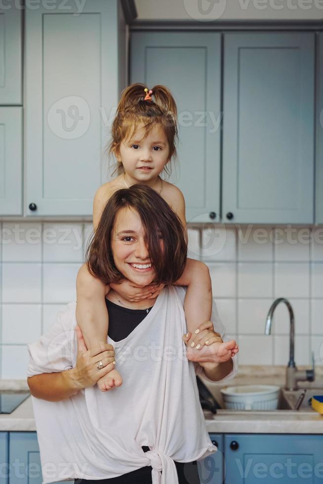 hermosa hijita que lleva a cuestas a su madre feliz foto