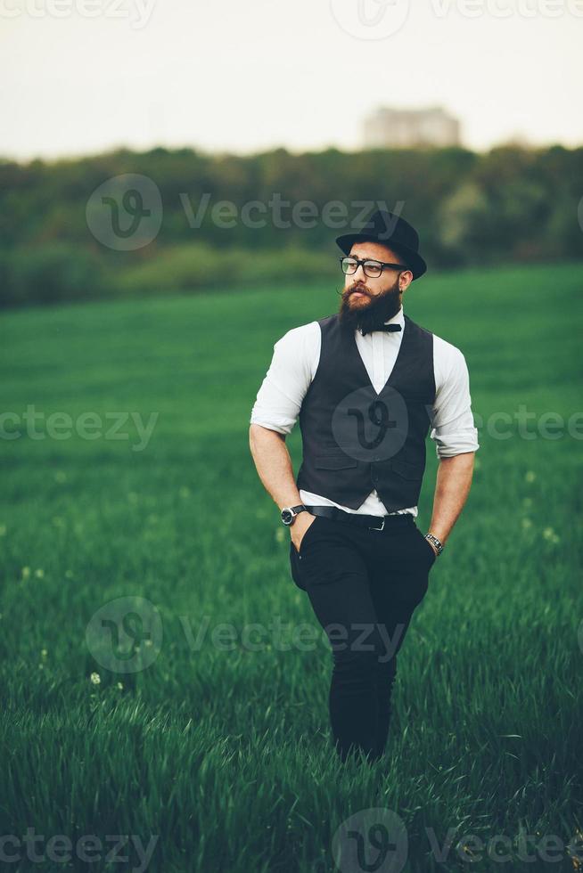 A man with a beard and sunglasses walking on the field photo