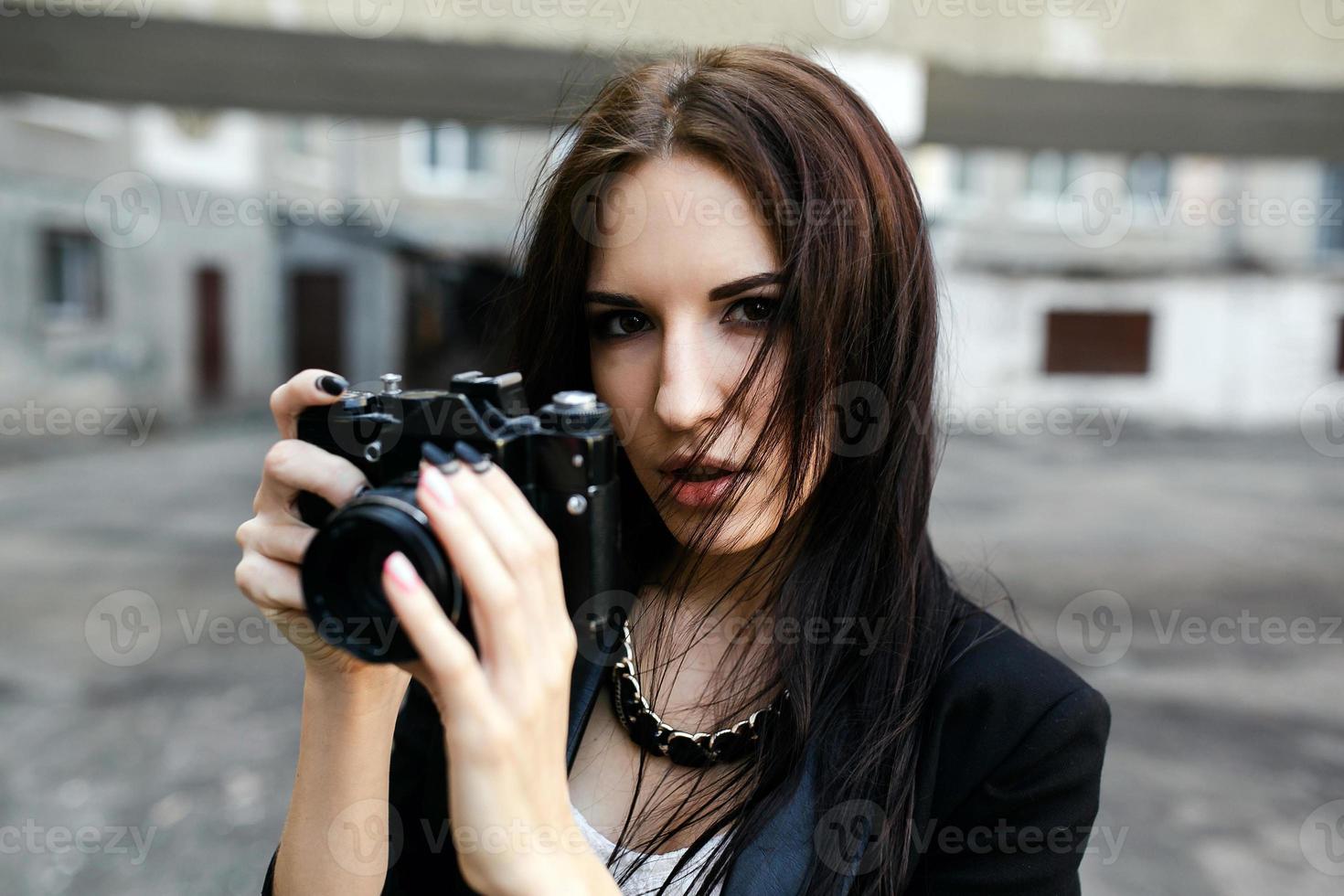 Beautiful female photographer posing with camera photo