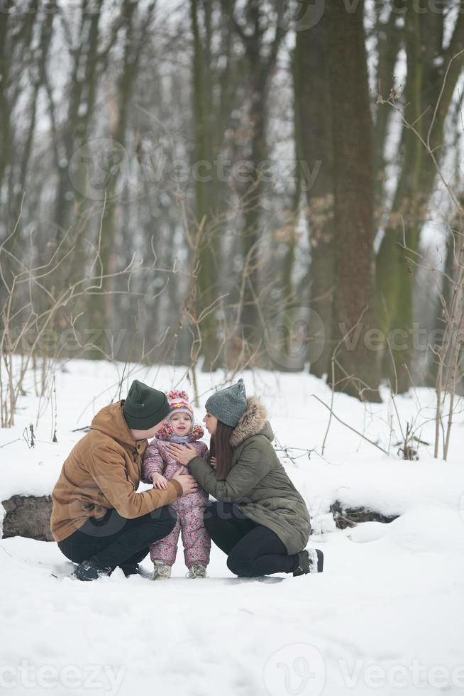 Dad and Mom with a little daughter in the park photo