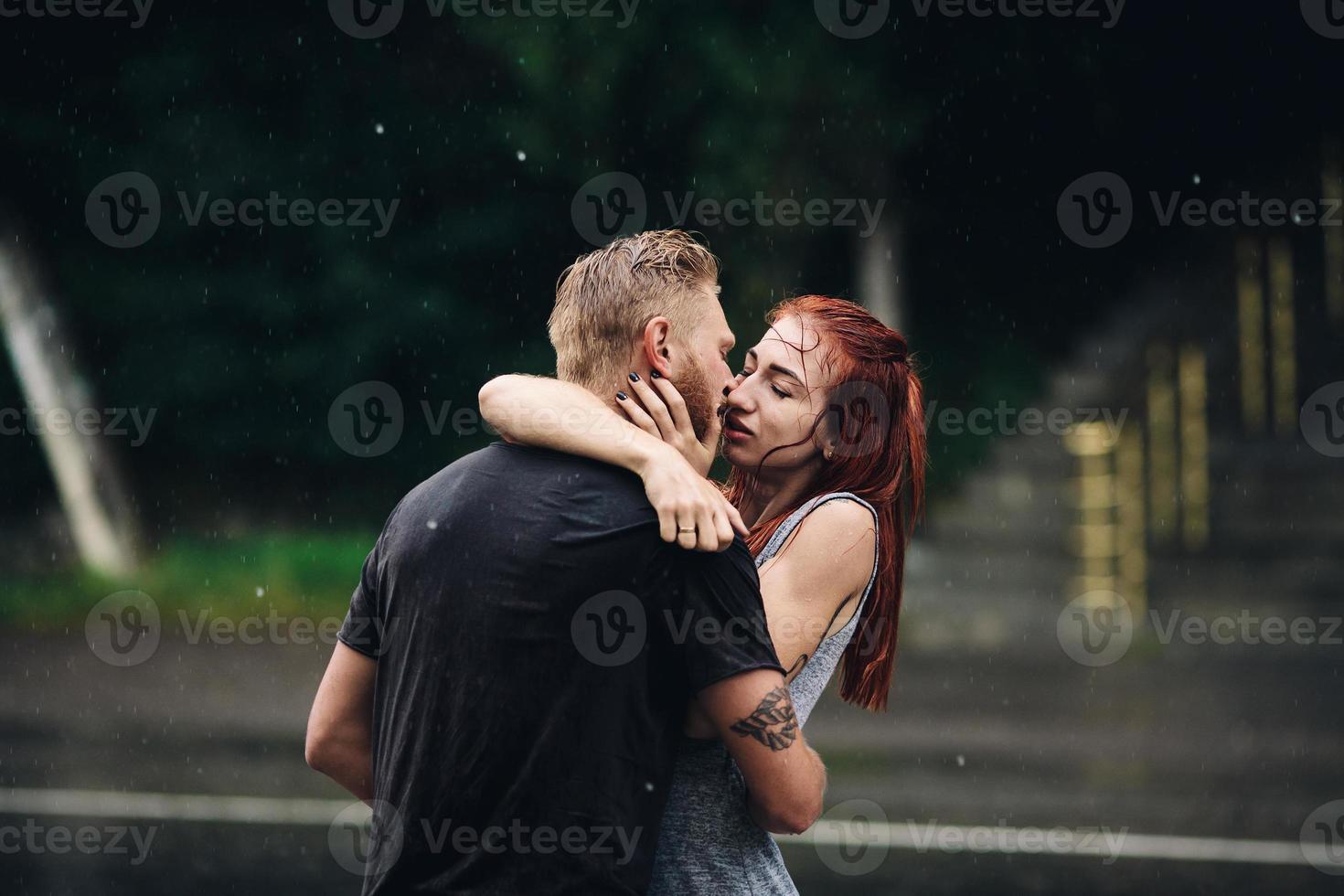 beautiful couple kissing  in the rain photo