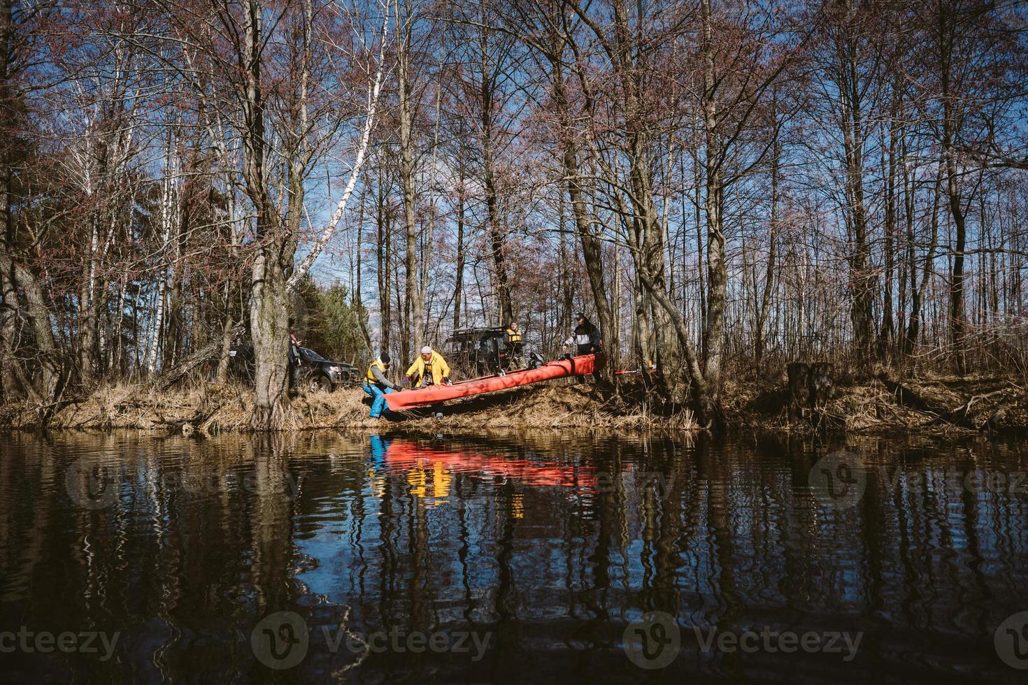 la gente está haciendo kayak en el río en el bosque. foto