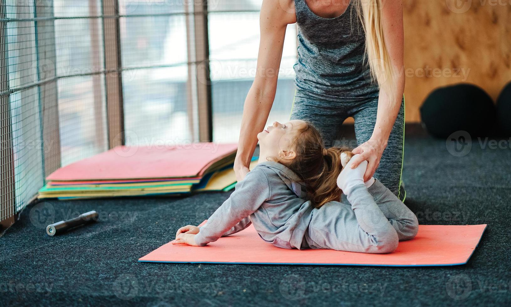 A little girl repeats exercises for her mother photo